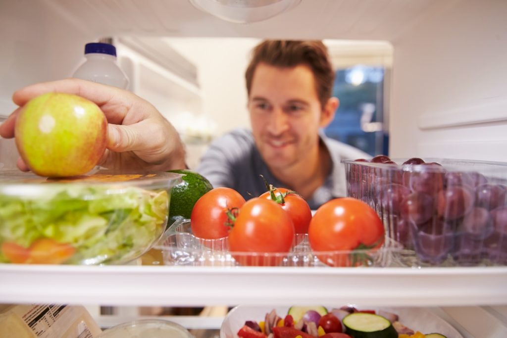 Man getting an apple from the fridge