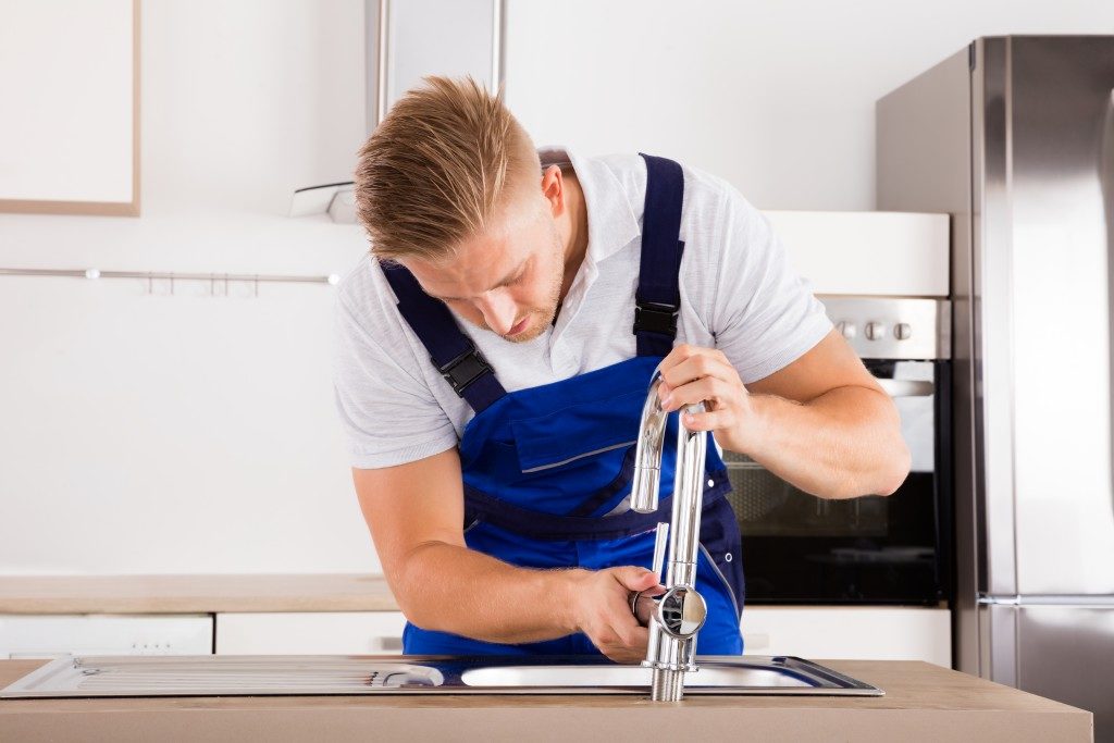 handsome plumber fixing the faucet