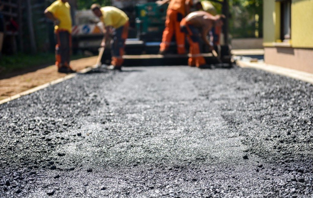 Team of Workers making and constructing asphalt road construction with finisher