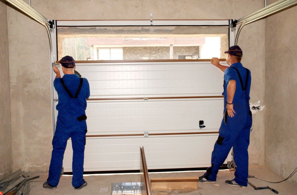 two men installing insulator in the garage