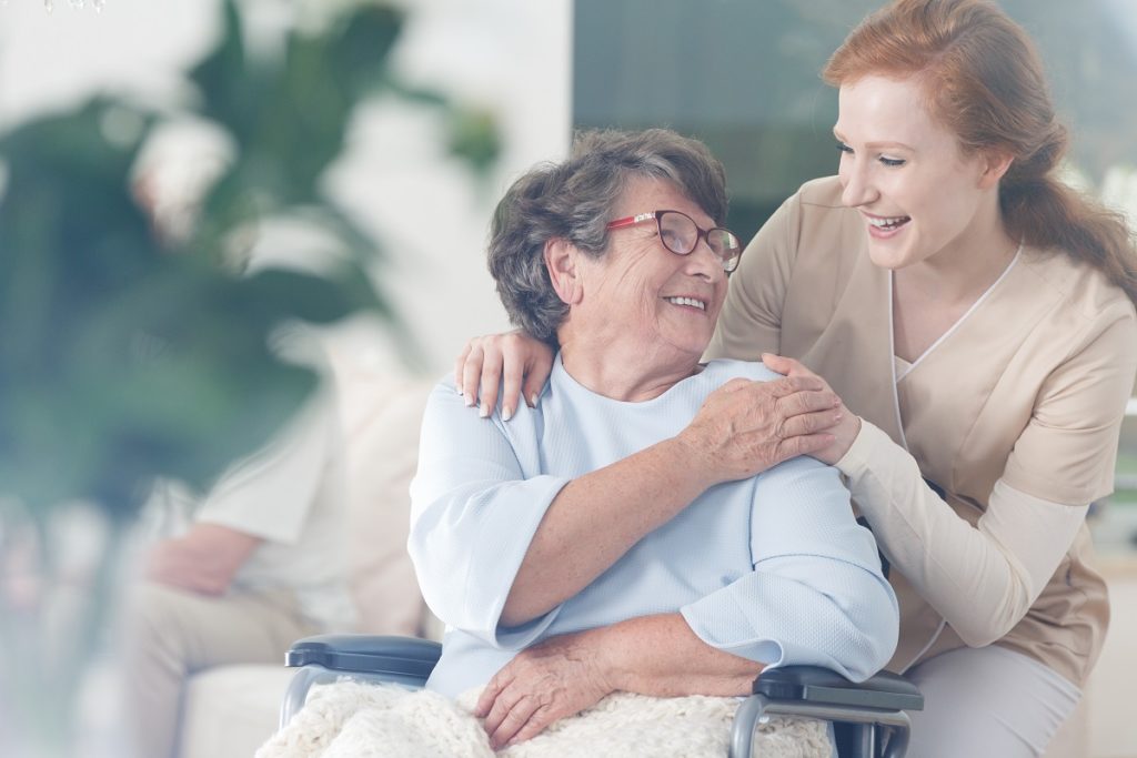 Elderly woman happily holding the hand of younger woman