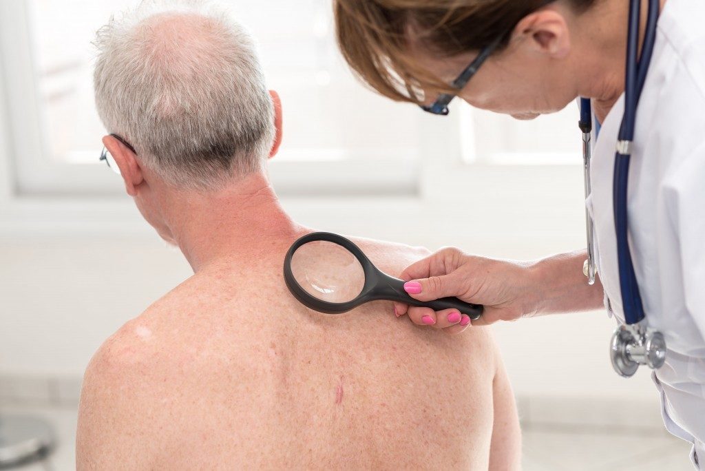 Doctor checking patient's skin