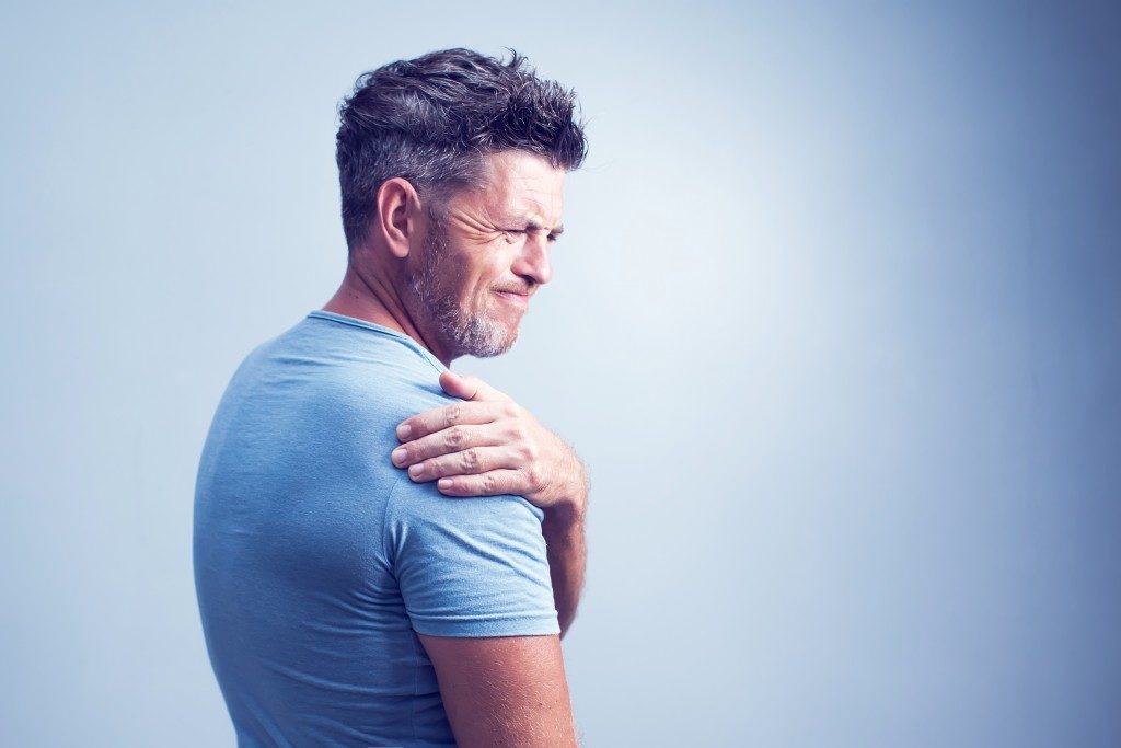 man experiencing pain in his shoulder