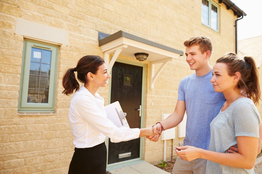 couple shaking hands with a real estate agent
