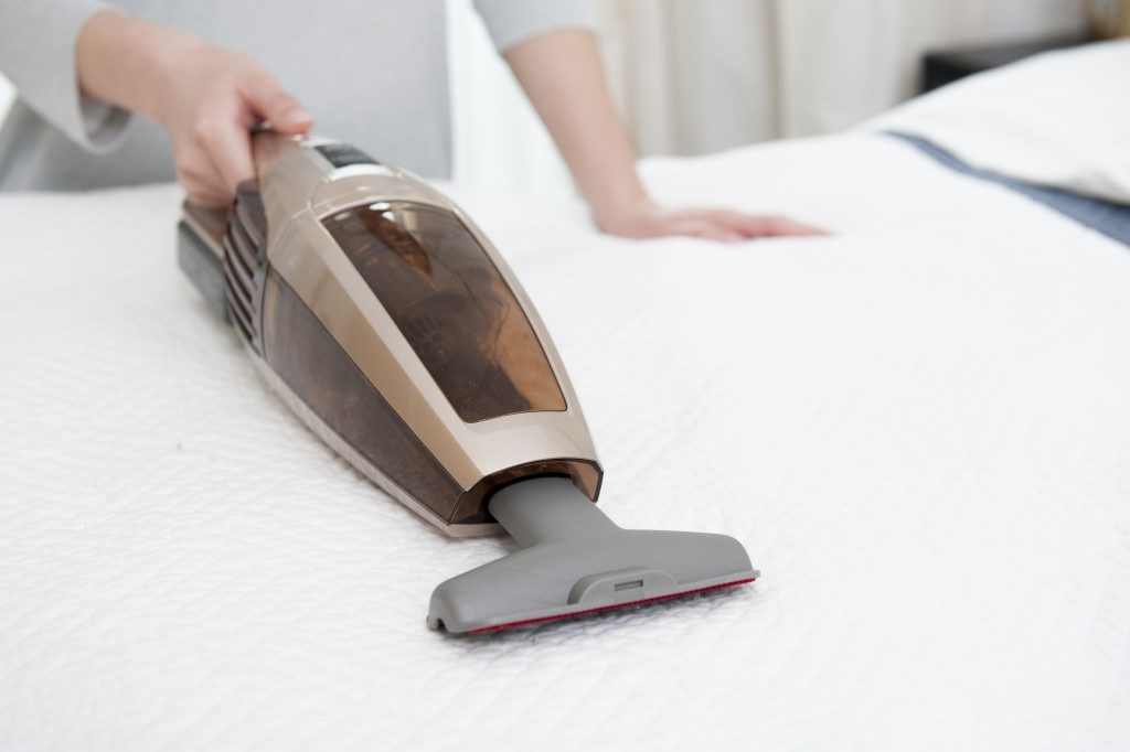 woman vacuuming the mattress