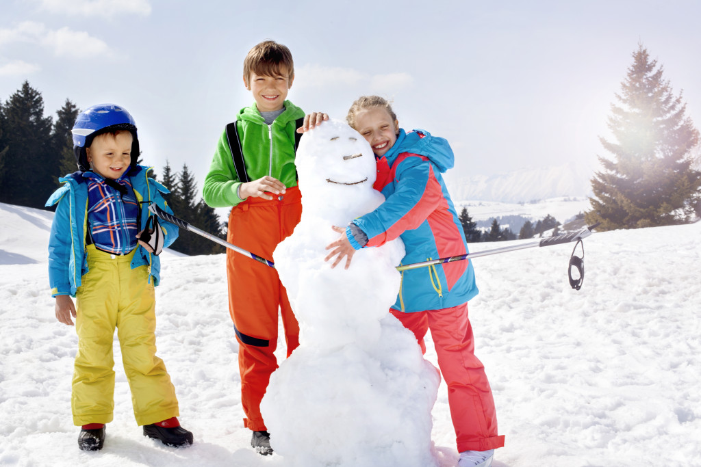 Children playing in the snow and making a snowman
