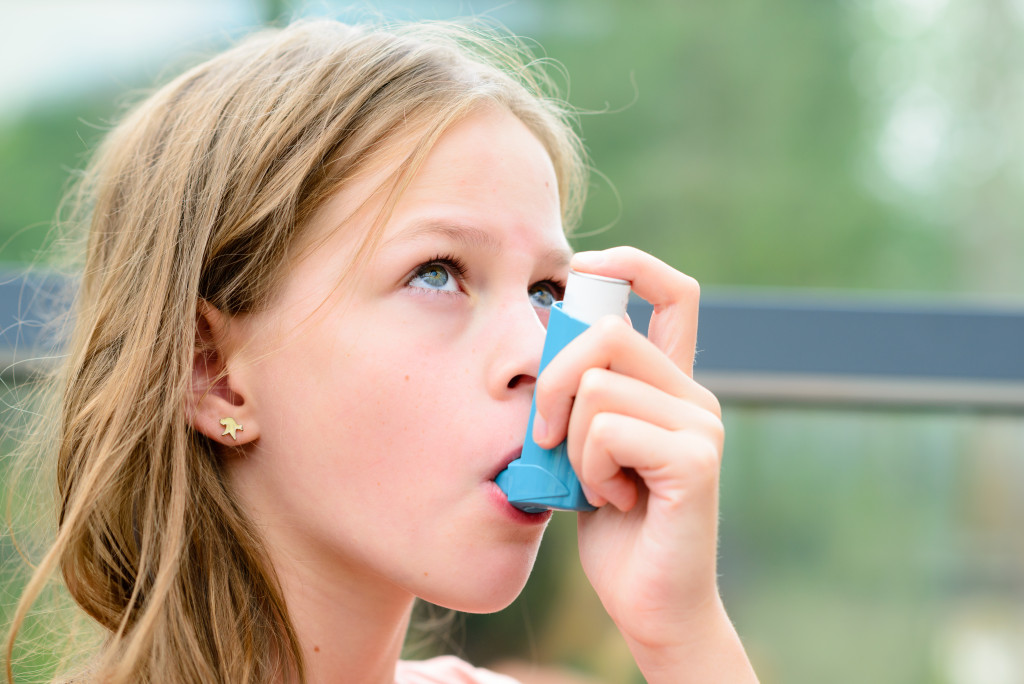 asthmatic girl using an inhaler