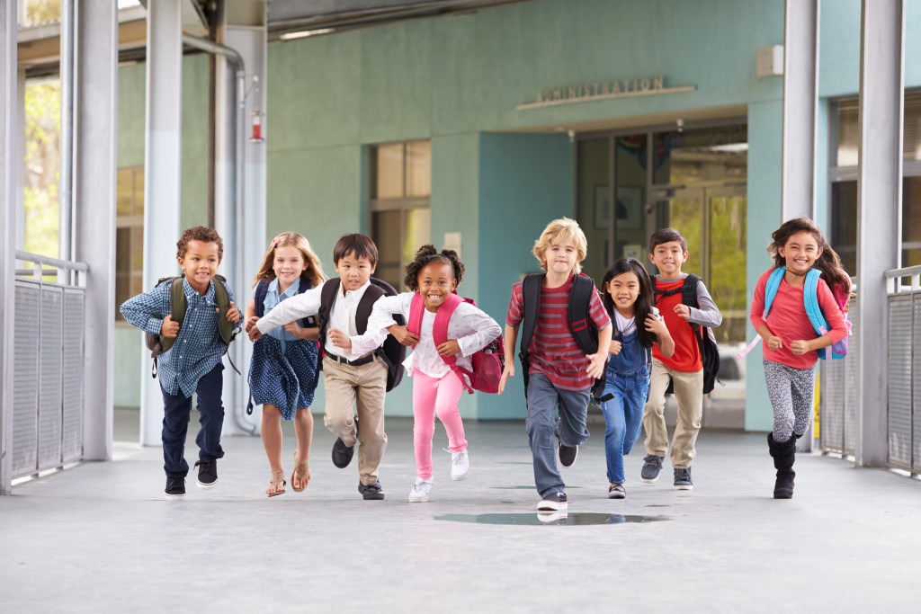 little kids running wearing backpacks