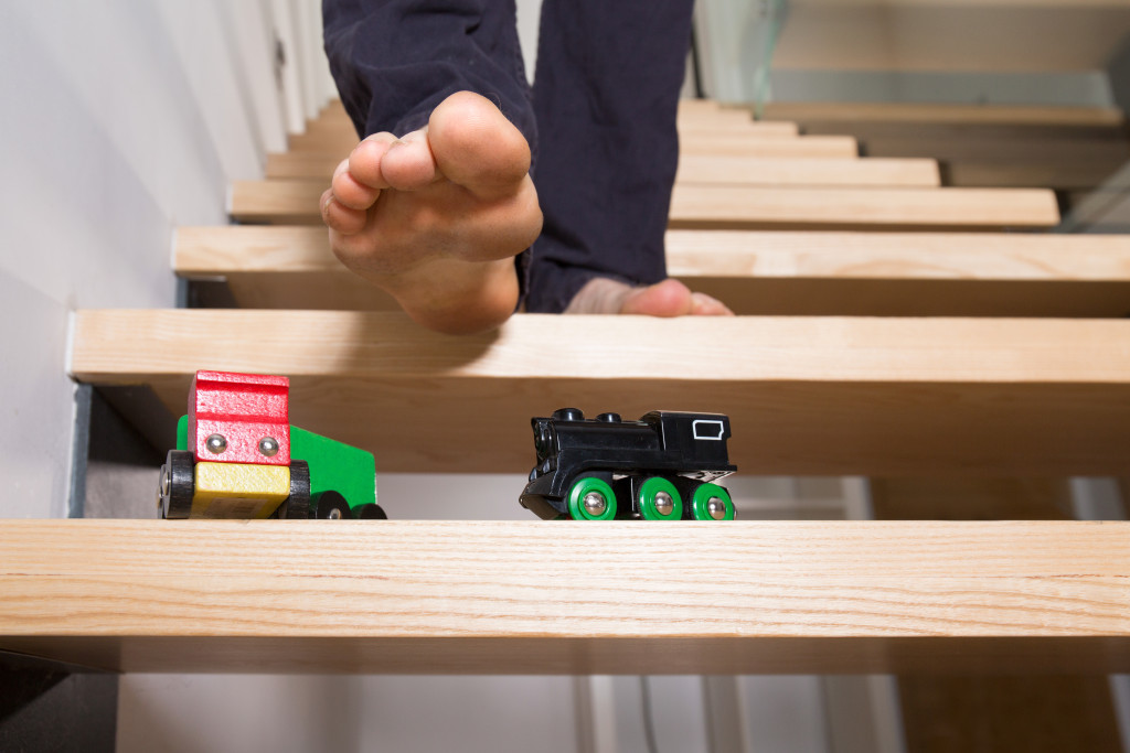 man's foot and toys left on stairs