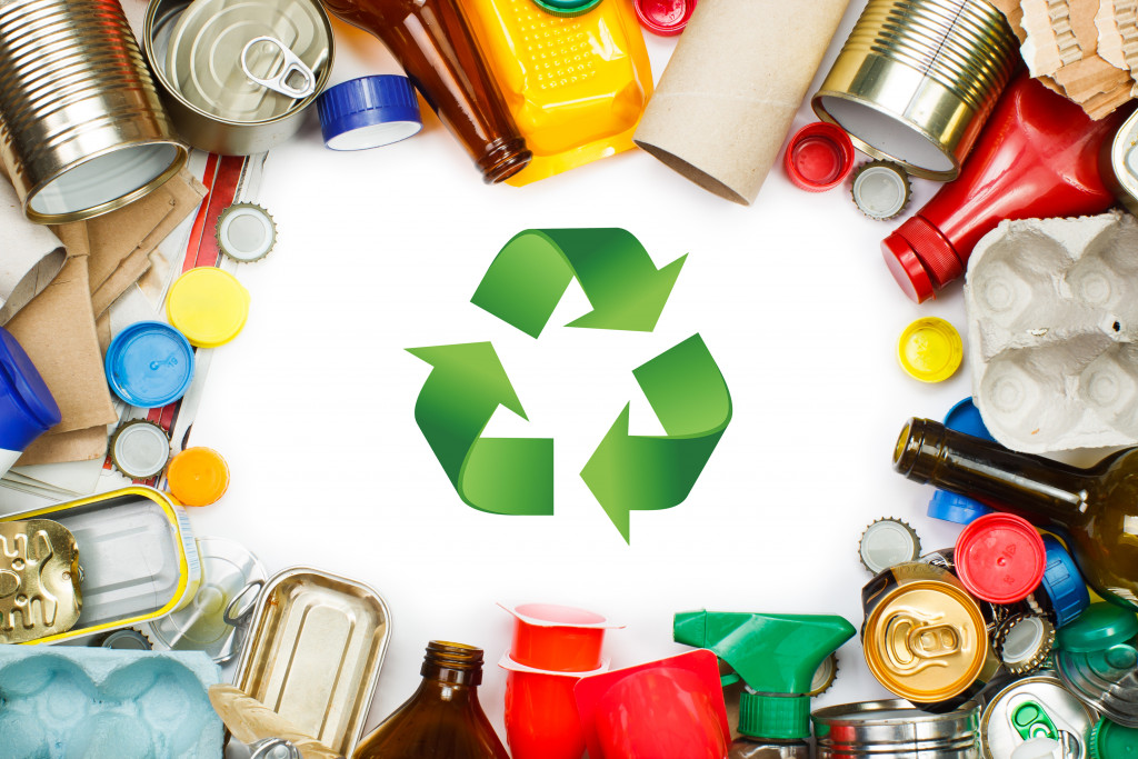 green recycle logo in the middle of different kinds of trash