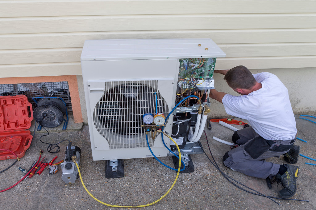 A man repairing the exhaust unit of a home HVAC