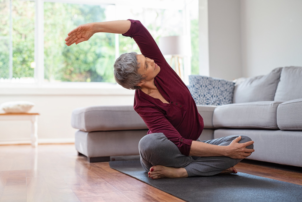 Active mature woman doing stretching exercise