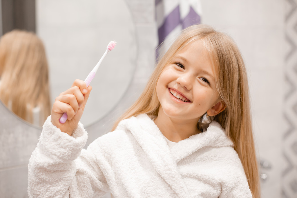a girl happily brushing her teeth