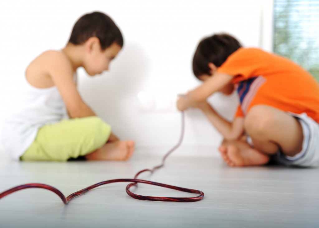 children playing with unsafe electric outlet