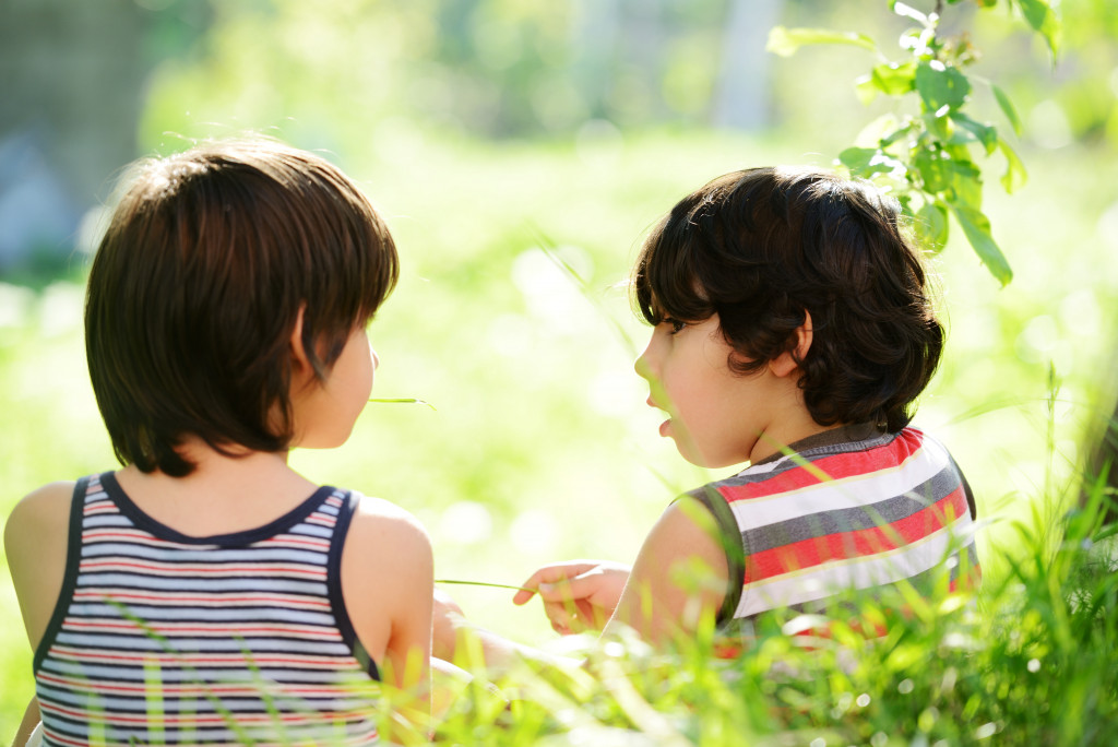 2 kids outdoor talking to each other