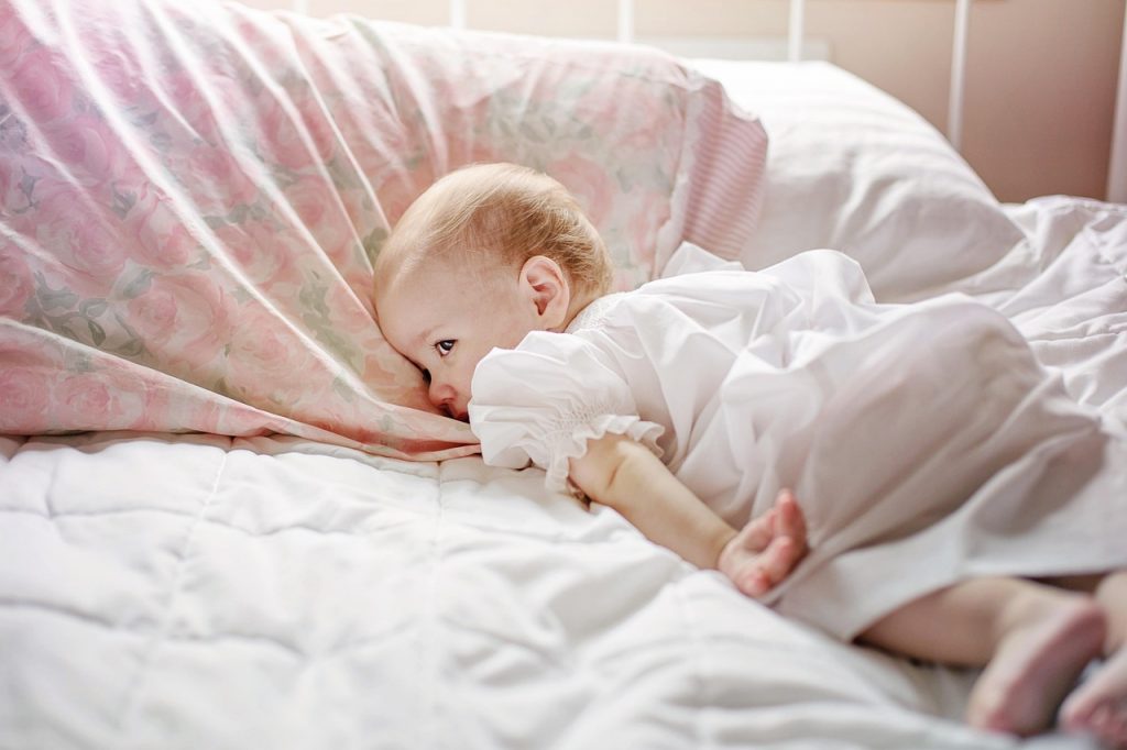 toddler in bed, awake and looking around