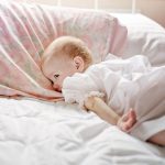 toddler in bed, awake and looking around